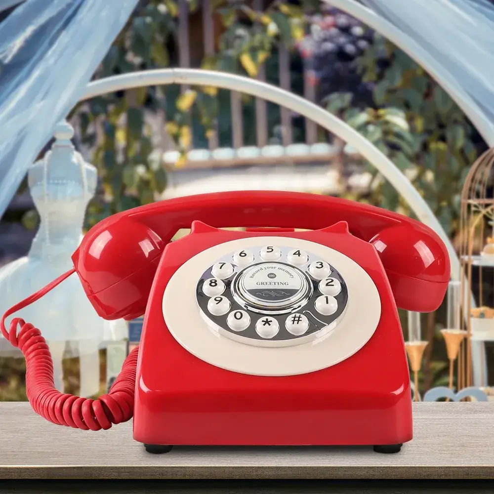 Telefon retro roșu Classic50 Red pe o masă, în fața unei arcade decorate pentru nuntă