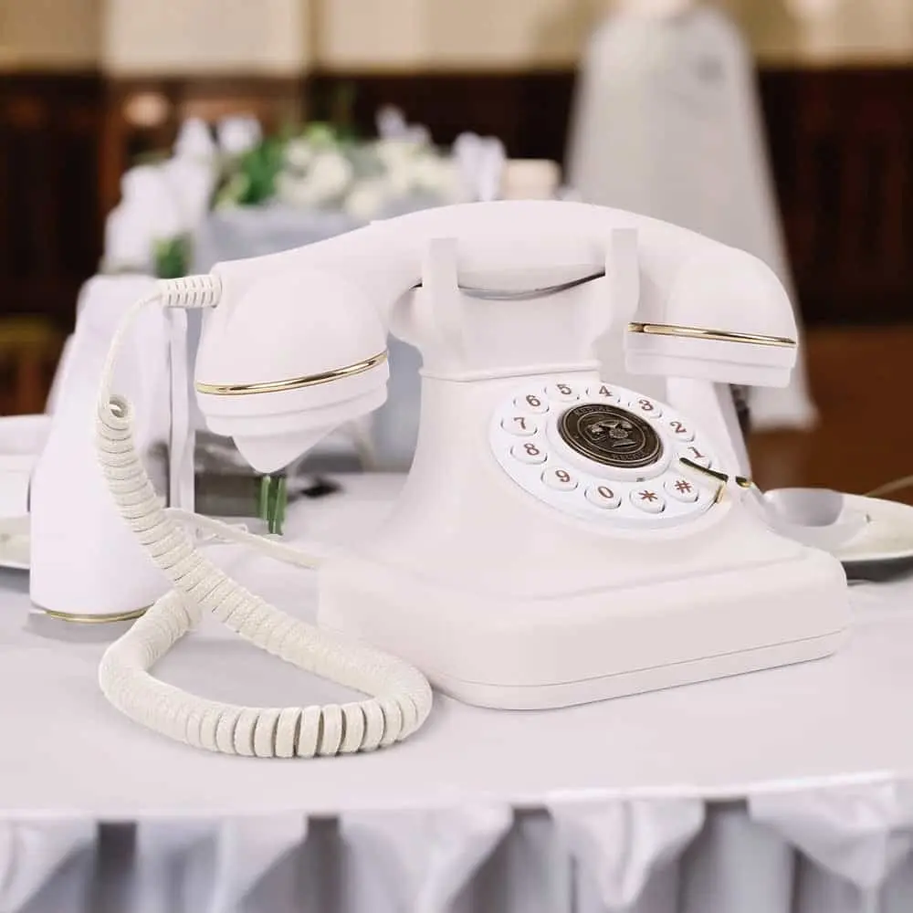 Telefon alb în stil vintage pe o masă cu față de masă albă